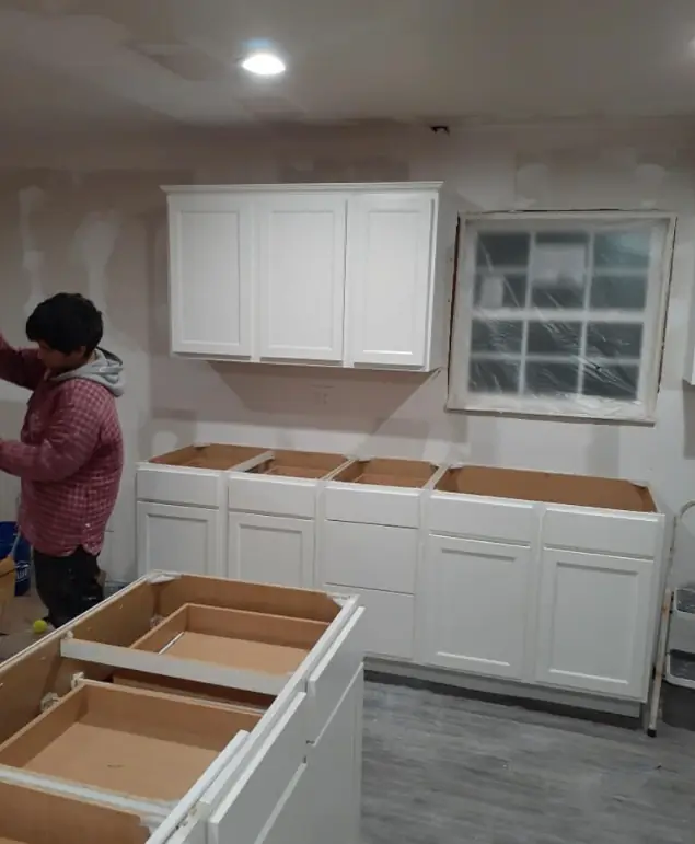 White shaker kitchen cabinets partway through installation